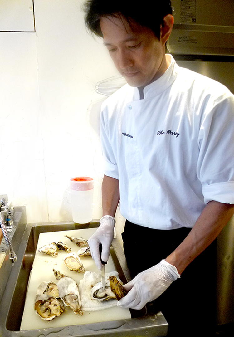 「安心、安全な食材」を日々厳選、調理する田中シェフ。カキのさばき方はさすが