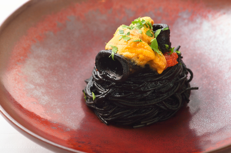 濃厚なイカスミソースがフェデリーニの細麺に絡み合う『ヤリイカのスミ煮のフェデリーニ　生ウニ添え』。上に載ったウニとのコントラストも魅力
