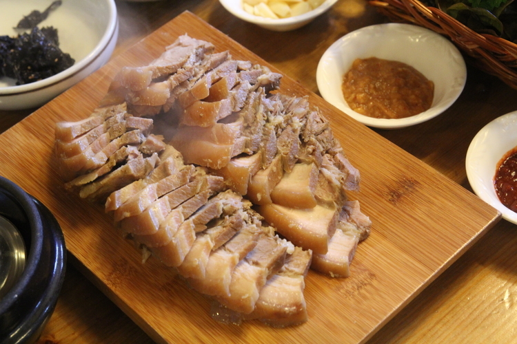茹で豚をまな板ごと提供する郷土料理の『トムベゴギ』