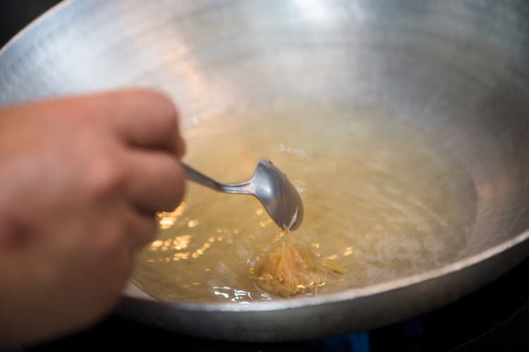 清湯に具の１つ、干貝をほぐしたものを入れる。干貝は一晩水につけて戻しておいたものだ。豆腐を入れる前に軽くとろみをつける。