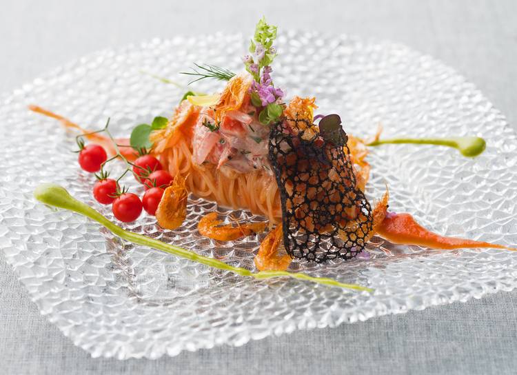 夏の間（6~9月）に供される、野崎シェフのスペシャリテ『桜海老の冷製カペリーニ トマト 山葵』。旬の食材を彩り豊かに使用しています
