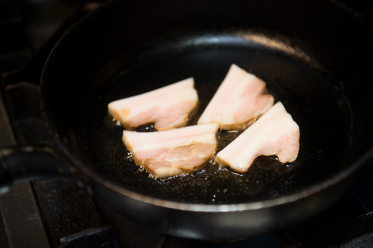 鹿児島産の皮付き豚バラ肉は、皮と脂を少し切り落としてから、胡麻油で焼き付ける。