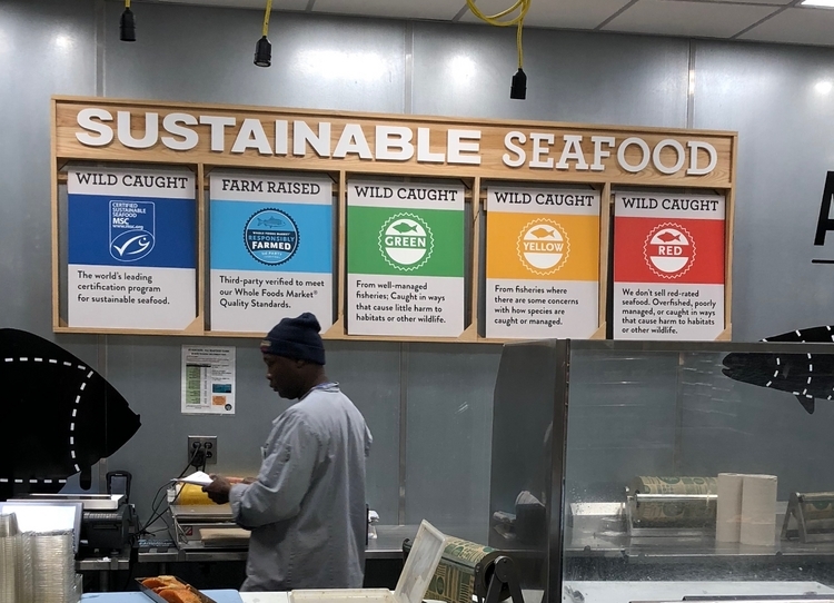 魚売り場。「サステナブルシーフード」というタイトルのもと販売する魚のガイドラインを掲示。右の３つは「シーフード・ウォッチ」と呼ばれる色分けシステムで、天然魚の資源状況を豊富にある／注意が必要／枯渇 という三段階で表示