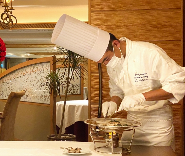 目の前で魚をデクパージュ（ゲストの前で料理を切り分け、皿に盛り付けてサービスを行う方法）する杉本料理長