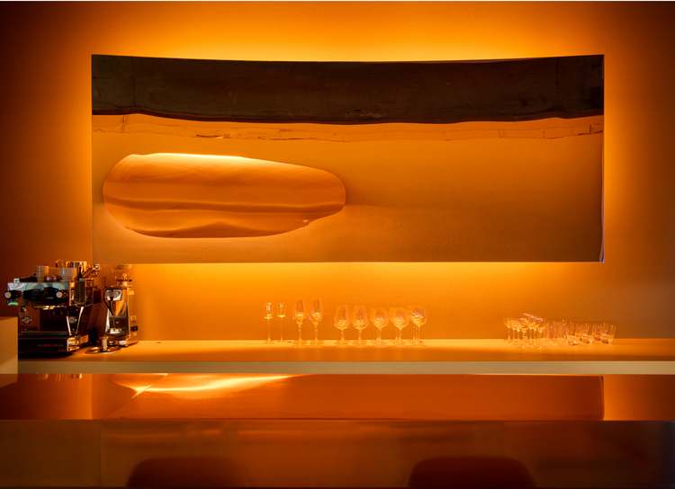 入り口に近いカウンター席とテーブル席は、オレンジの光に包まれた温かな雰囲気が漂います。カウンターの中央に飾られた鏡に映るオレンジの円のオブジェが、まるで太陽のよう
