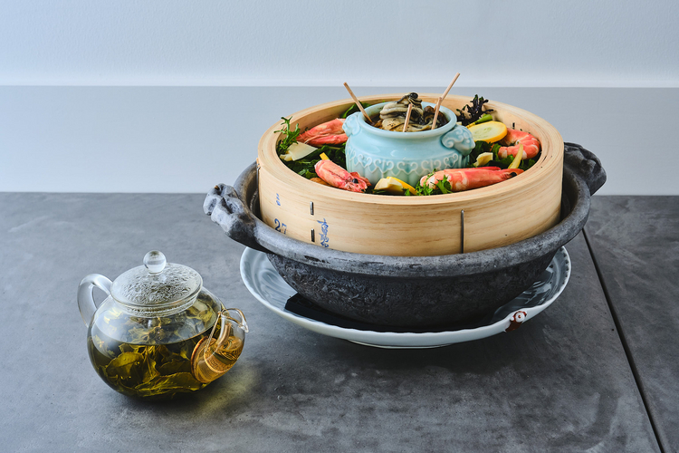 鍋の上に置かれた蒸籠とガラスのティーポットに入った台湾烏龍茶