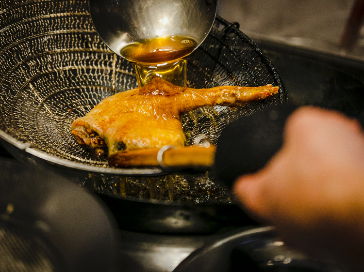 スパイスでマリネして低温で４時間蒸した鴨の腿肉を熱い油を何度もかけてパリッと揚げる