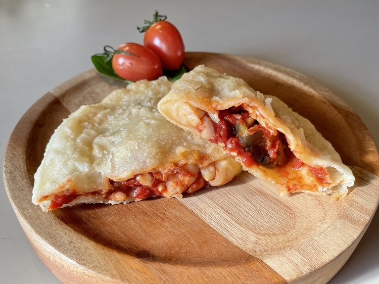 シチリア島の伝統的なレシピで作られた具材に、自家製トマトソースやフレッシュモッツァレラチーズ、素揚げをしたナスを使用