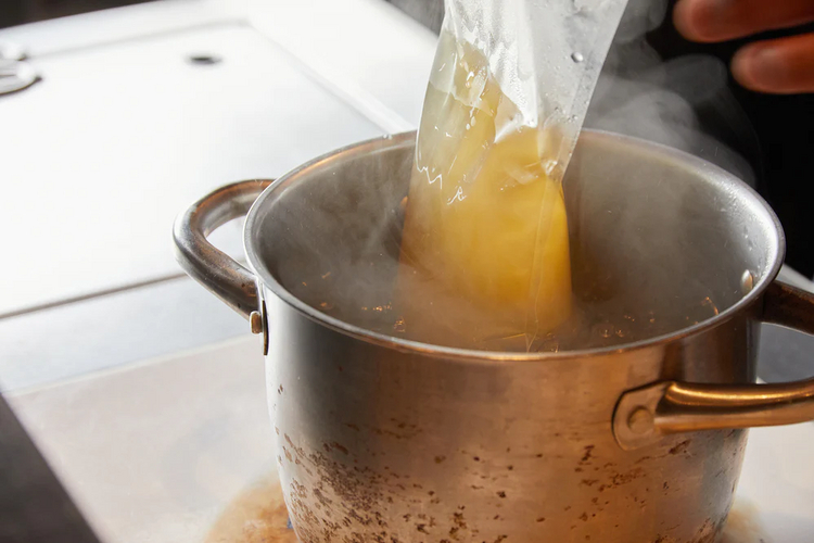 木津川ねぎ塩ラーメンのスープとチャーシューを袋のまま湯煎で温めます