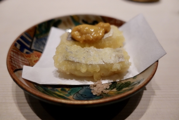 「太刀魚の天ぷらをどうぞ、違いを楽しんでください」と言って供された逸品がこのビジュアル。片方に何かのってます（笑）