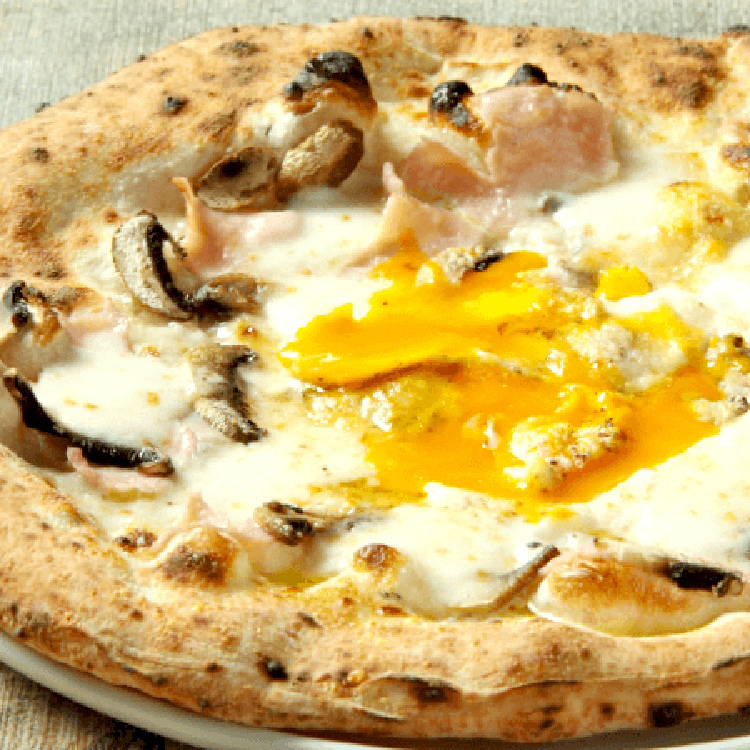 仕上げに半熟卵をのせた人気のビスマルク。ピッツァはアラカルト約１６種と多彩