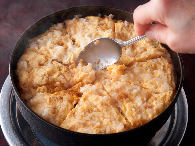 鍋の旨みが凝縮された〆の『おじや』はコゲが旨い逸品。すき焼きに使用した溶き卵をかけることで、自分だけのオリジナルの味わいに仕上がっています
