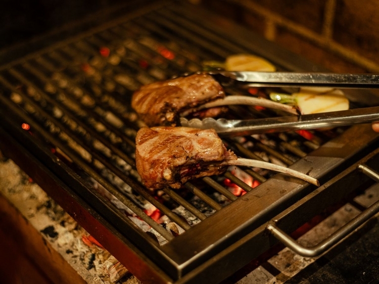 薪の熾火でじんわりと焼き上げていく骨付き仔羊のロースは、タスマニア産。ここでは、薪のほかに炭火も用意。食材で使い分けている