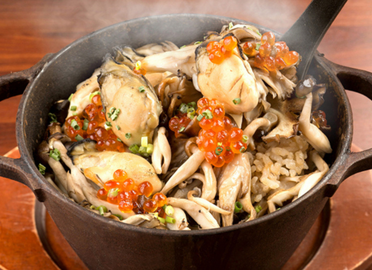 アツアツの鉄鍋で提供される人気メニュー『鉄鍋で炊き上げる牡蠣の炊き込みご飯』