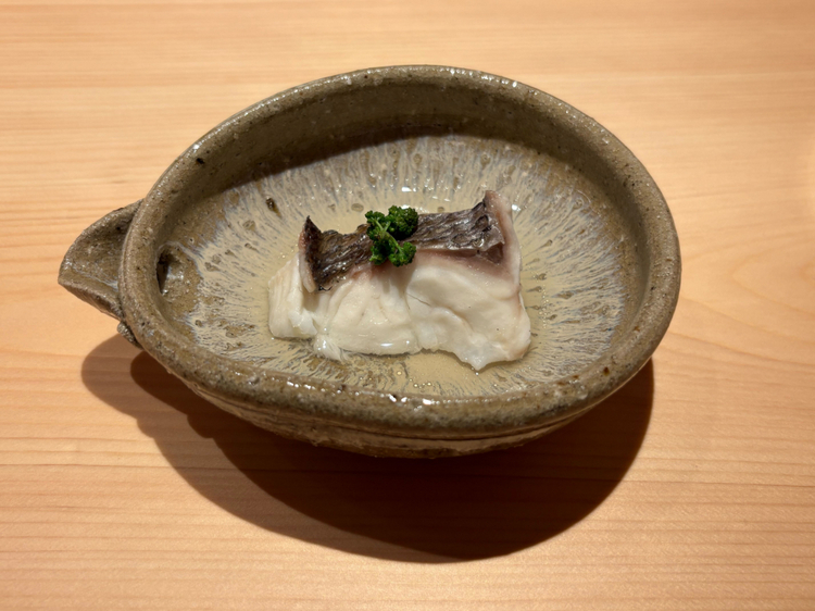 1皿目：神経締めの『真鯛』。ふっくらとした身に、岡山産の花山椒が香りを添え、透明感あるあさりのだしとともに味わう一品