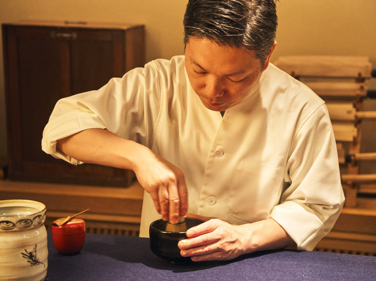 カウンターに紺の毛氈（もうせん）を敷き、その上でお茶を点てる物江さん