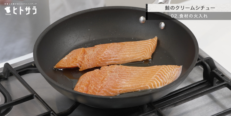 02.鮭のクリームシチュー／食材の火入れ：オリーブオイルを引いたら火をつける前に必ず皮目を下にしてフライパンに入れ、強火で皮目がカリカリになるまで焼くことで旨みが倍増します。両面焼き色がついたら一度取り出し、同じフライパンで野菜を炒めます。
