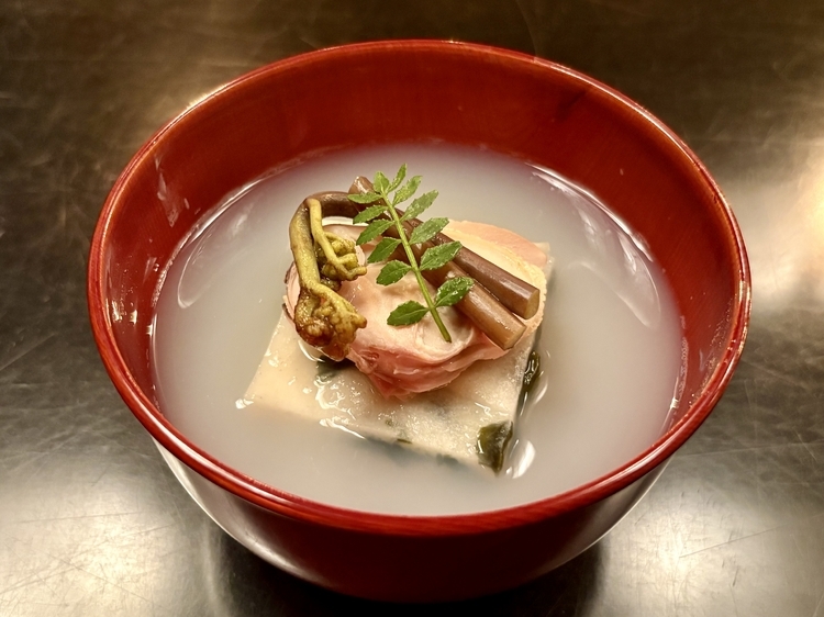 朱塗りのお椀の中に広がるのは、蛤の旨みが凝縮されたおだし。若布真薯（わかめしんじょ）の柔らかな食感と、蛤の弾力が重層的な味わいをつくり出しています。