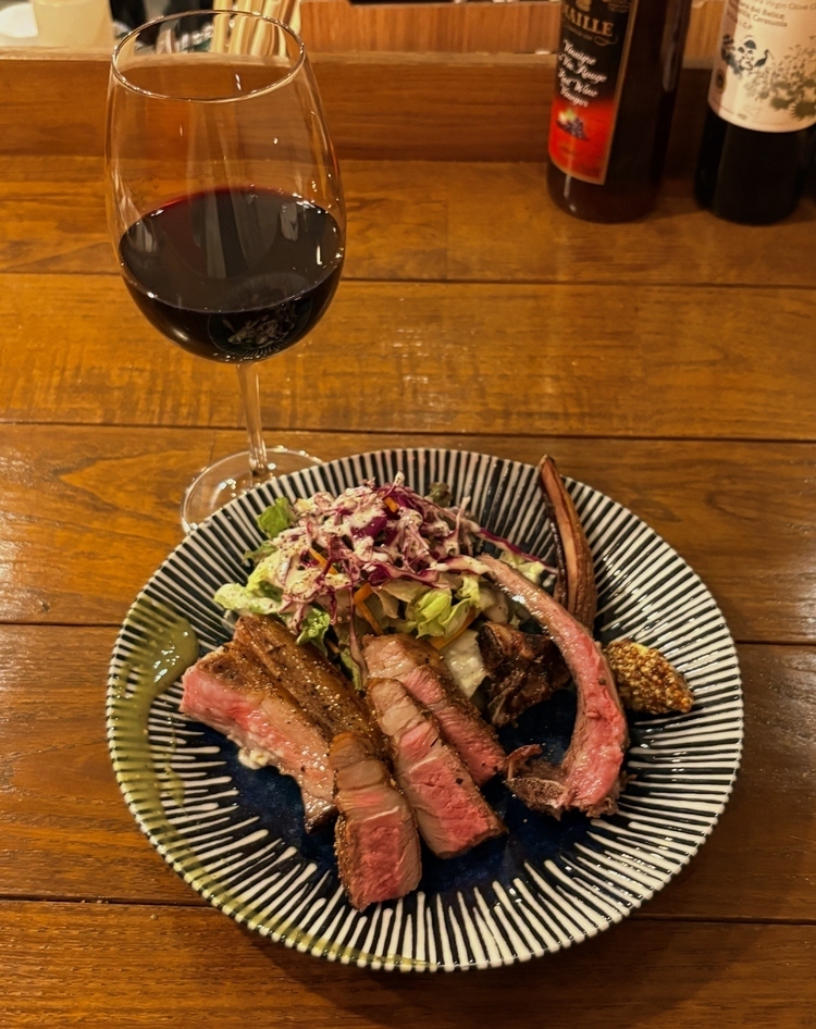 『骨付きラム肉』1,800円。各国から厳選されたワインはグラスでオーダー（700円） 