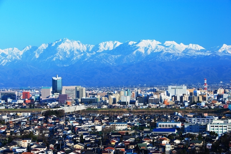 立山連峰に見守られるように広がる富山市。写真は呉羽山からの風景